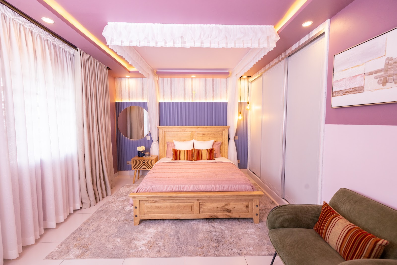 Primary bedroom suite with layered neutral textiles, timber bed frame and warm cove lighting